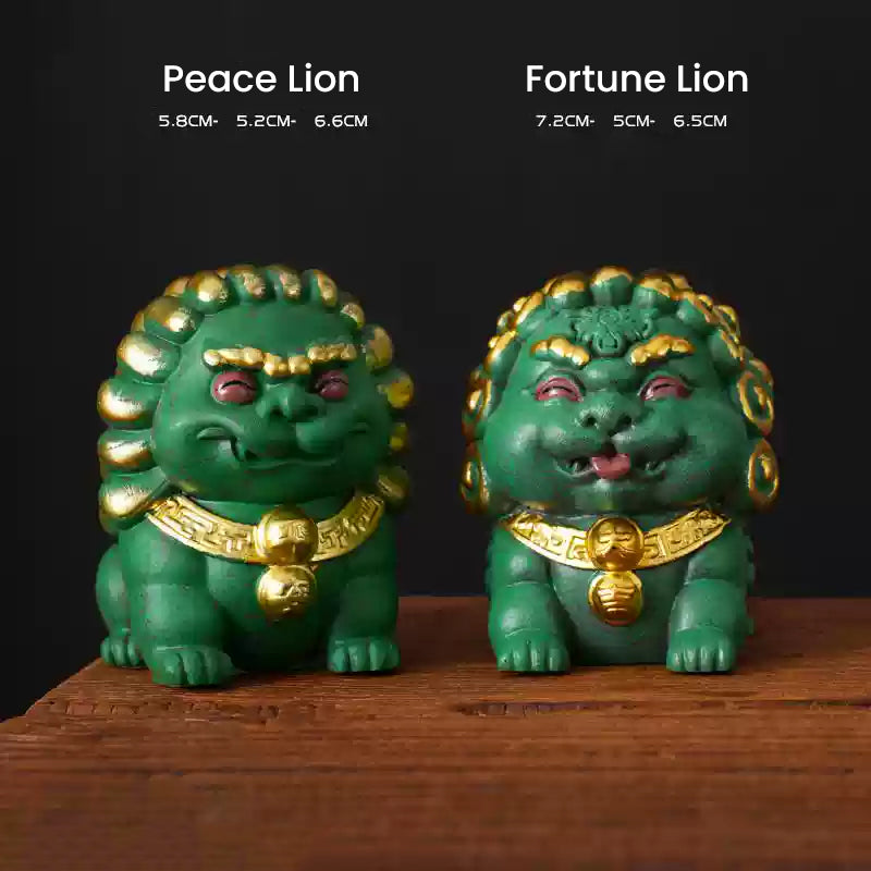 A pair of green mini stone lions, the Peace Lion and Fortune Lion, adorned with golden details, displayed side by side on a wooden surface with their dimensions noted above, symbolizing protection and prosperity.