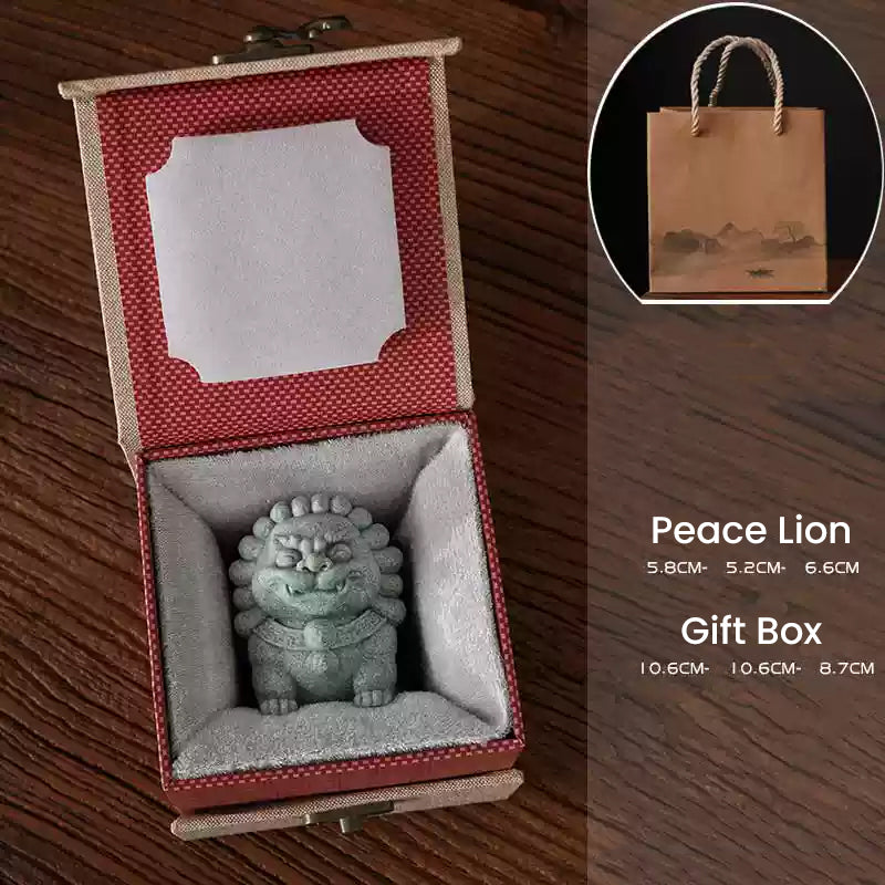 A Peace Lion ornament crafted from green sandstone, displayed in a red-lined gift box with a paper bag in the background, highlighting its dimensions as a perfect gift option for protection and harmony.