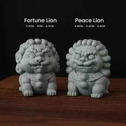 A pair of green sandstone ornaments featuring the Fortune Lion and Peace Lion, symbolizing prosperity and protection, displayed side by side on a wooden surface with their dimensions noted above.