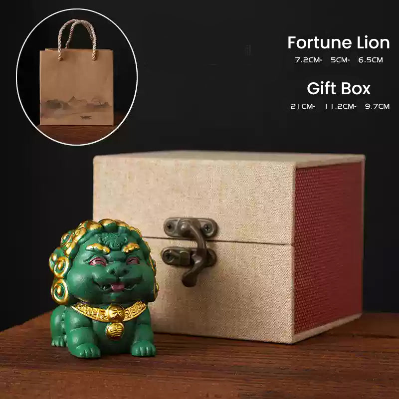 A green Fortune Lion ornament with gold details displayed beside a beige gift box and a paper gift bag, highlighting its dimensions and suitability as an elegant gift option.