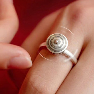 A person spinning a rotatable S925 sterling silver ring on their finger, showcasing the sleek design and calming spinning motion for mindfulness and stress relief.