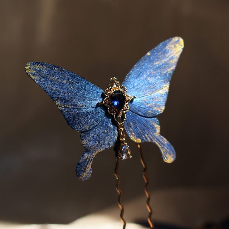 A dazzling handcrafted blue butterfly hair accessory by Chujiu Mountain Atelier, featuring golden details and a radiant blue crystal centerpiece, perfect for adding a touch of elegance to any hairstyle.






