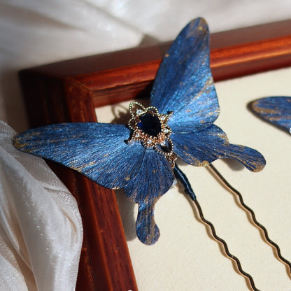 A beautifully handcrafted blue butterfly hairpin by Chujiu Mountain Atelier, showcasing intricate golden accents and a stunning blue gemstone at its center, perfect for elevating your style.