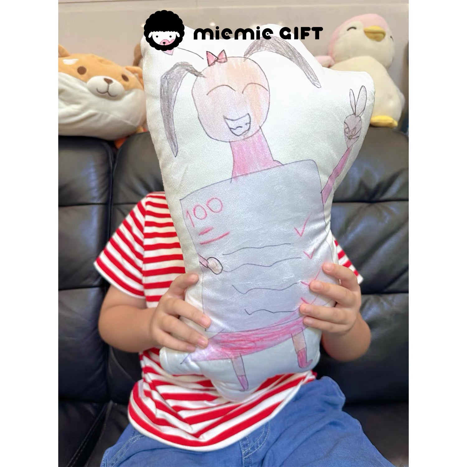 Personalized pillow featuring a child’s colorful drawing, held by the artist, highlighting the playful and heartfelt transformation from art to a huggable memory.

