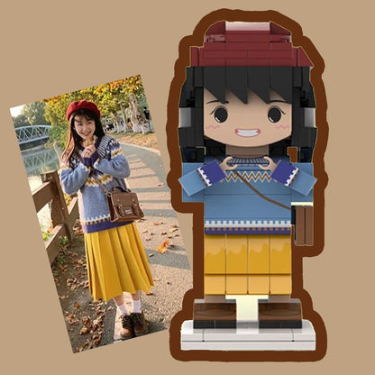 Custom brick figurine alongside the original photo, showcasing detailed outfit matching with a blue sweater, yellow skirt, and red hat.