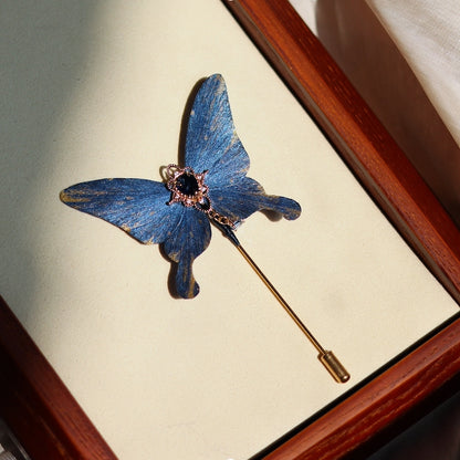 Handcrafted deep ocean blue velvet butterfly brooch by Chujiu Mountain Atelier, adorned with a delicate blue crystal centerpiece, golden accents, and a sleek pin design for sophisticated elegance.