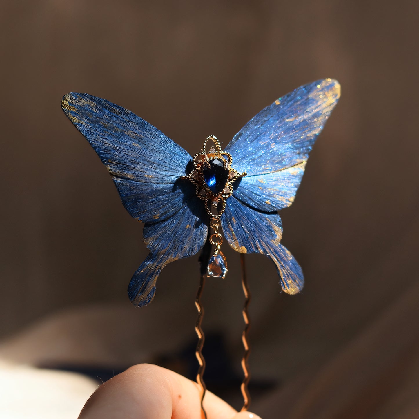 Handcrafted deep ocean blue velvet butterfly hairpin by Chujiu Mountain Atelier, featuring golden accents, a teardrop-shaped blue crystal centerpiece, and a dangling charm, perfect for a refined and graceful look.