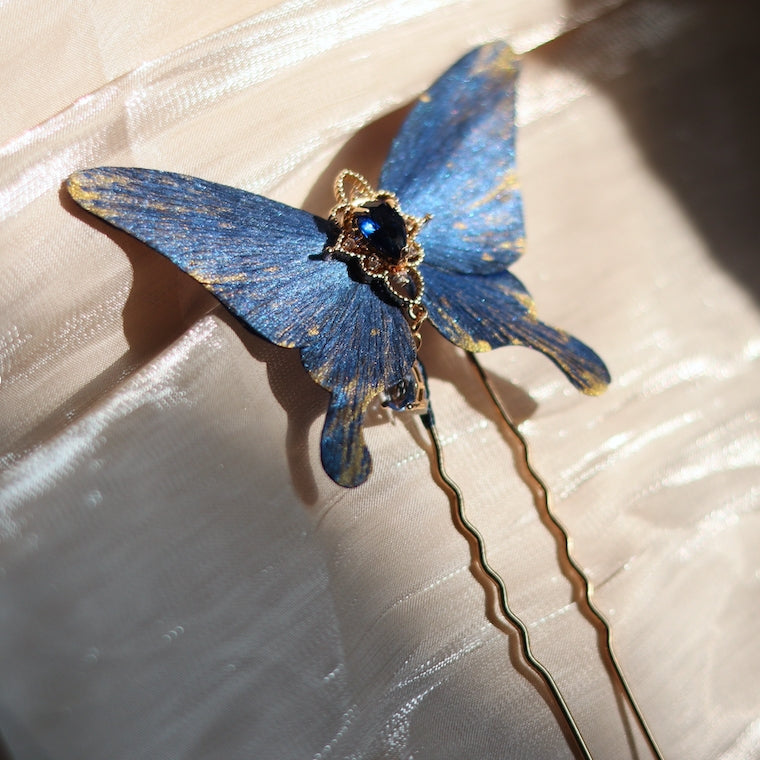 Handcrafted deep ocean blue velvet butterfly hairpin by Chujiu Mountain Atelier, featuring golden accents, a radiant blue crystal, and delicate craftsmanship inspired by the serene elegance of the ocean.