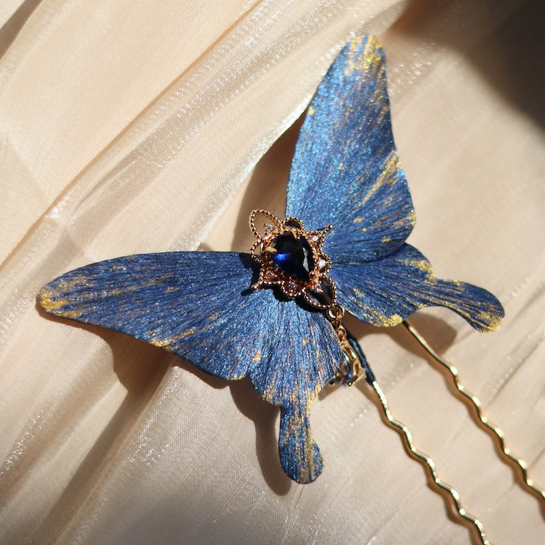 Handcrafted deep ocean blue velvet butterfly hairpin by Chujiu Mountain Atelier, featuring a sparkling blue crystal centerpiece, shimmering golden accents, and an elegant design inspired by the ocean's beauty.