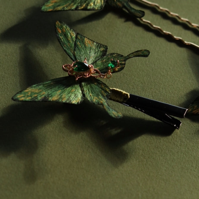 Detailed view of a handcrafted emerald green velvet butterfly hair clip by Chujiu Mountain Atelier, featuring golden accents, heart-shaped green crystals, and a delicate design for versatile styling.