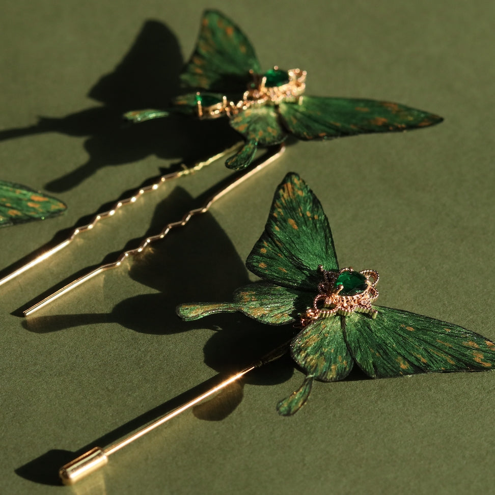 Set of handcrafted emerald green velvet butterfly hairpins by Chujiu Mountain Atelier, featuring golden accents, heart-shaped green crystals, and a luxurious finish perfect for elegant hairstyles.