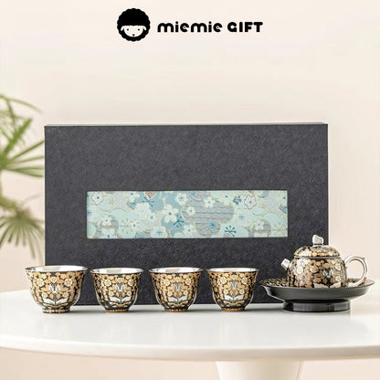 Golden Branches & Jade Leaves Gilded Silver Tea Set beautifully displayed with a luxurious gift box, featuring four intricately designed cups, a teapot, and tray, blending elegance and traditional craftsmanship.