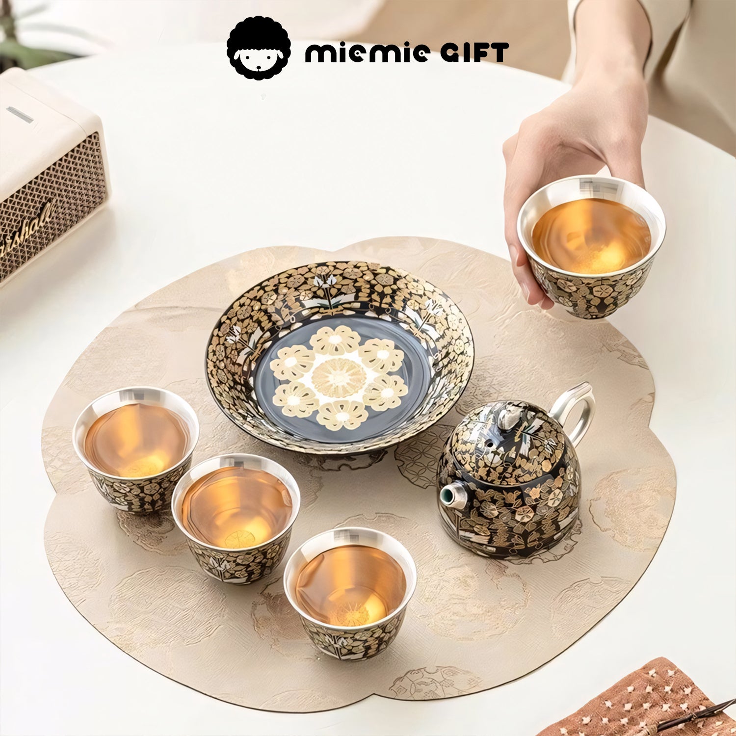 Golden Branches & Jade Leaves Gilded Silver Tea Set arranged for sharing, featuring a teapot, tray, and cups filled with tea, highlighting its intricate floral design and cultural elegance.