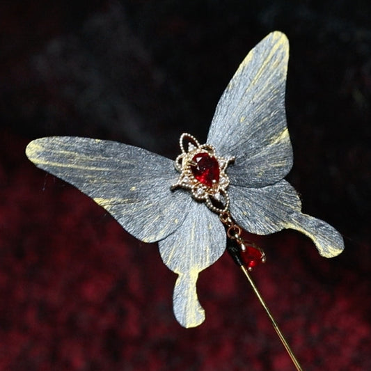 Handmade gray butterfly velvet flower hairpin featuring a striking red gemstone centerpiece, accented with gold detailing, showcasing exquisite traditional craftsmanship.