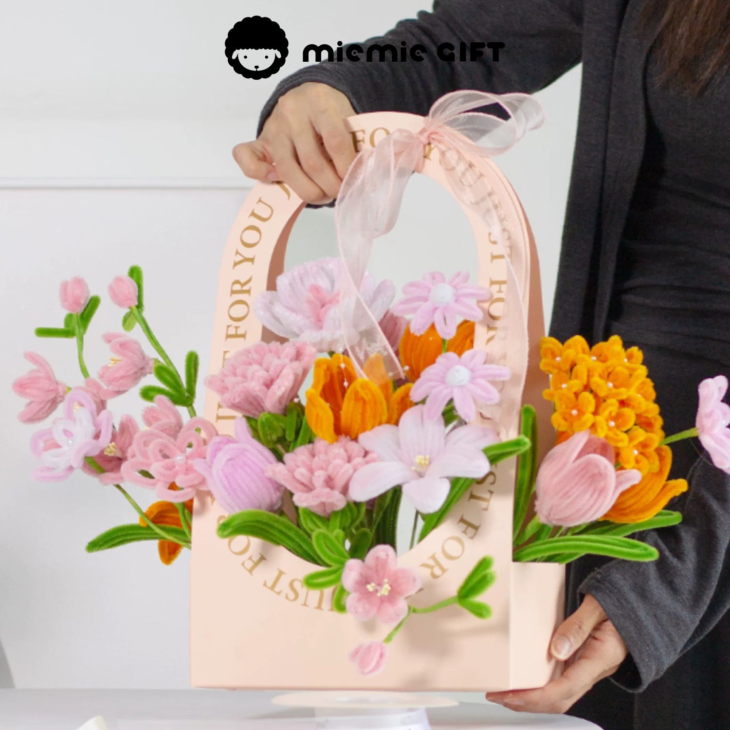 MieMie Gift DIY Flower Basket held by hand, featuring vibrant handmade pipe cleaner flowers in pink, orange, and white tones, perfect for home decor or gifts.