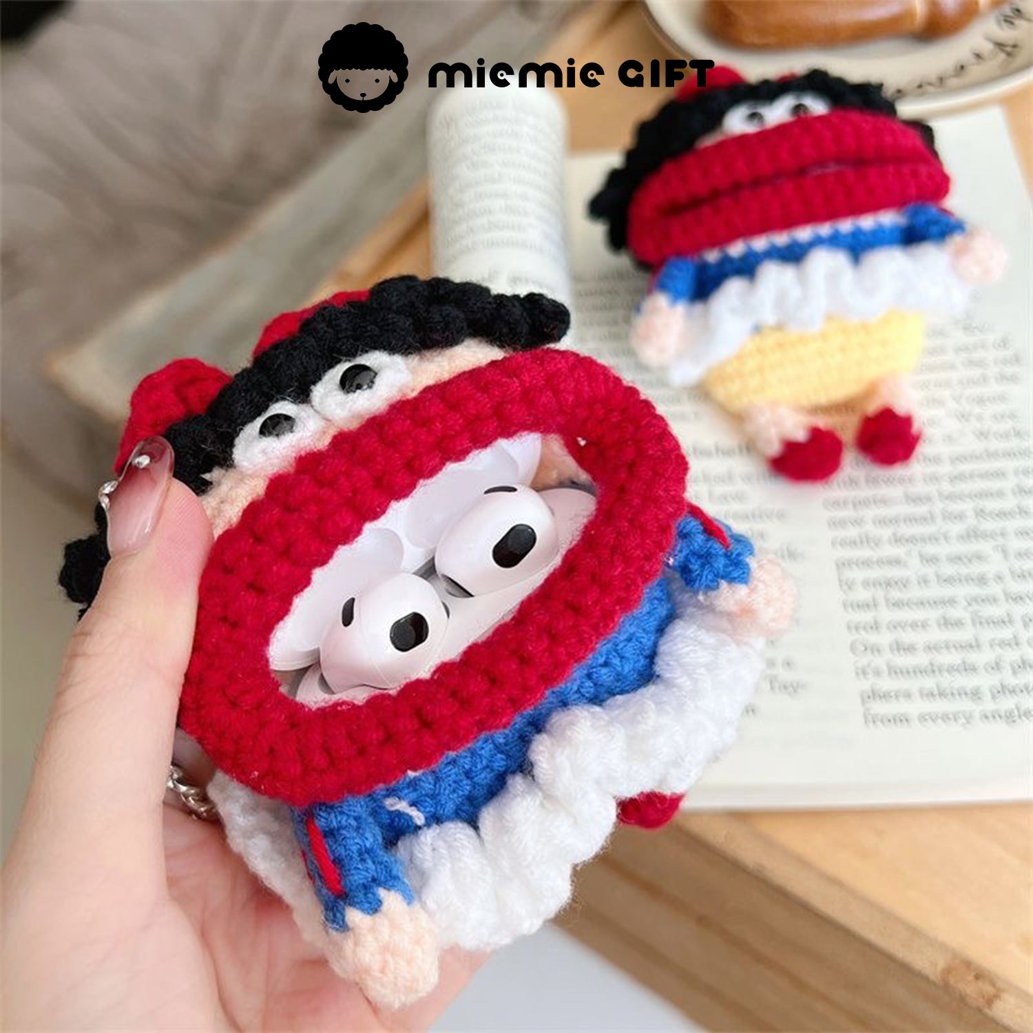 Snow White knit earphone case held in hand, showing the case with AirPods inside. The case features a fun, colorful design with a red bow and a black curly-haired Snow White character.