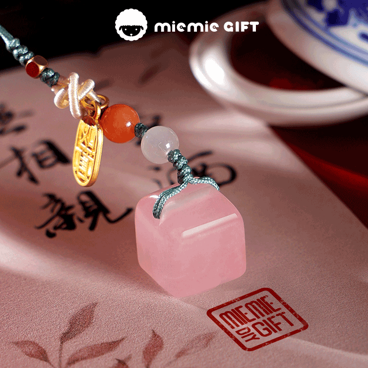 Handcrafted pink quartz seal adorned with intricate beads and a golden ruyi charm