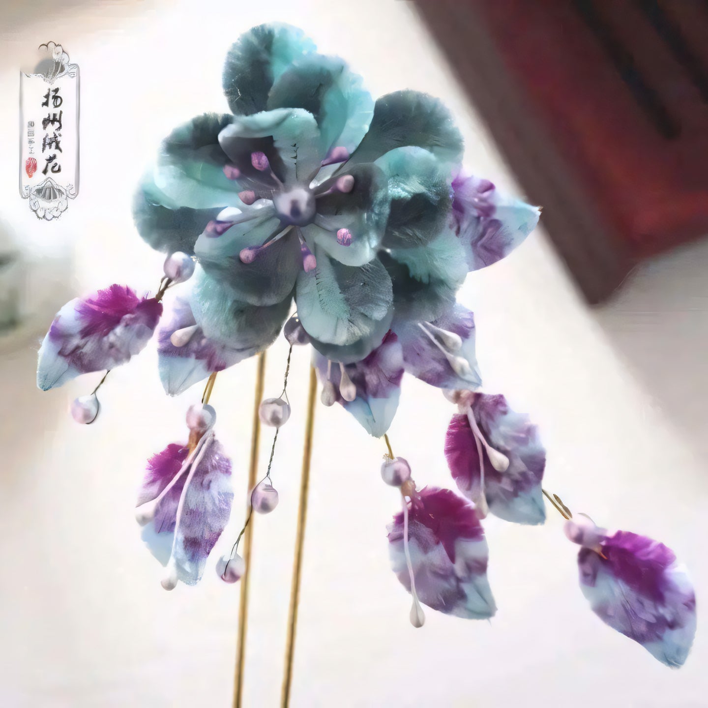 Elegant purple and teal velvet flower with cascading beads and pearl accents, showcasing traditional craftsmanship.