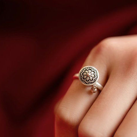 Elegant S925 sterling silver rotatable ring with intricate lotus flower design worn on a hand, symbolizing blessings, mindfulness, and good fortune.