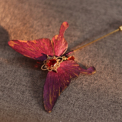 Handcrafted royal purple velvet butterfly brooch by Chujiu Mountain Atelier, featuring golden accents and a red heart-shaped crystal, offering an elegant and timeless accessory for special occasions.