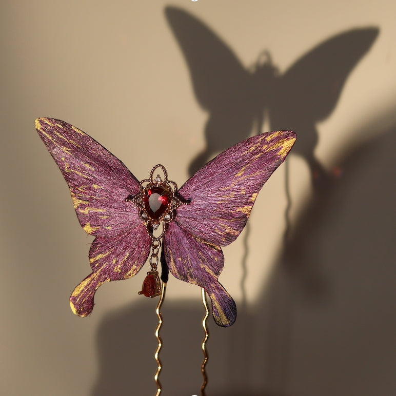 Handcrafted royal purple velvet butterfly hairpin by Chujiu Mountain Atelier, featuring golden accents, a red heart-shaped crystal, and delicate details inspired by regal elegance and mystery.