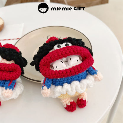 Snow White knit earphone case with AirPods inside. The case is crafted with colorful yarn in red, blue, and white, showcasing a playful Snow White character with a wide smile, black curls, and a red bow.